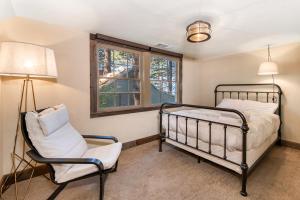 a bedroom with a bed and a chair and a window at Lakeview Manor in South Lake Tahoe