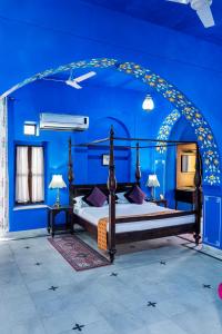 Diggi Palace - A City Center Hidden Heritage Gem في جايبور: غرفة نوم بجدران زرقاء وسرير في غرفة