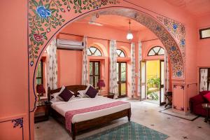 ein Schlafzimmer mit einem Bett in einem Zimmer mit einem Bogen in der Unterkunft Diggi Palace A Luxury Heritage Hotel in Jaipur