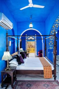 Diggi Palace - A City Center Hidden Heritage Gem في جايبور: غرفة نوم مع سرير والجدران الزرقاء