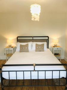 a bedroom with a large white bed with two lamps at Harbour House Looe in Looe
