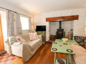 a living room with a couch and a wood stove at Elm Cottage in Oswestry