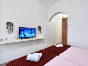 um quarto com uma cama e uma televisão na parede em Frank's House & Happy BELEM em Lisboa