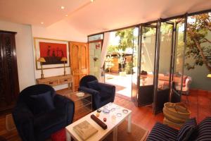 sala de estar con 2 sillas y mesa en * Couples and family secluded getaway + pool* en Ciudad del Cabo