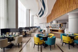 吉達的住宿－Radisson Blu Hotel, Jeddah Al Salam，一间带桌椅的餐厅和一间酒吧