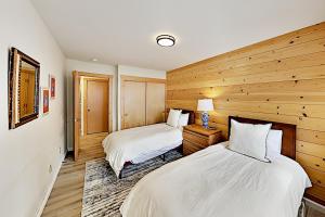 Dos camas en una habitación con paneles de madera. en Alpine Retreat, en Truckee 22 fotos más