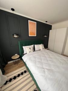 een slaapkamer met een groot bed met een groen hoofdeinde bij Caris Home in Hunedoara