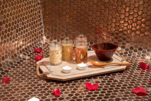 a tray with jars and a bowl on a table with flowers at Radisson Blu Hotel, Jeddah Corniche in Jeddah