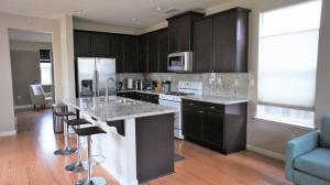 a kitchen with black cabinets and a kitchen island with bar stools at Modern Luxury Living, relax and enjoy your stay! in Rancho Cordova