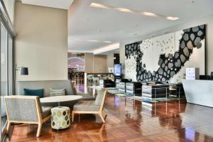 a lobby with a table and chairs in a building at Radisson Blu Gautrain Hotel, Sandton Johannesburg in Johannesburg