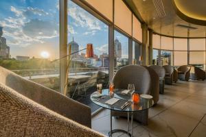 a restaurant with a view of a city skyline at Radisson Blu Gautrain Hotel, Sandton Johannesburg in Johannesburg