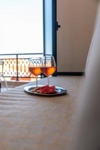 two wine glasses on a plate on a table at Marelina Villas in Panormos Rethymno