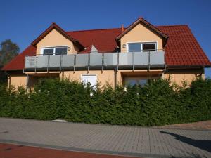 ein Haus mit Balkon darüber in der Unterkunft Usedom Ferienwohnungen Riwa ruhig in Ostseebad Kölpinsee