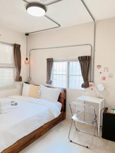 台南的住宿－旅樂台南民宿，一间卧室配有一张大床和一把椅子