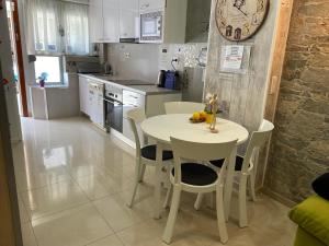 BADAROSA House10min to BARCELONA City&NearTo BEACH في بادالونا: مطبخ مع طاولة بيضاء وكراسي في غرفة