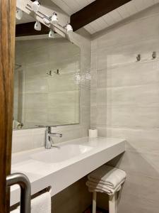 a white bathroom with a sink and a mirror at Hotel-Apartamentos La Arquera in Llanes +122 photos