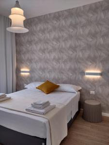 - une chambre avec un grand lit blanc et un mur dans l'établissement Room45, à Marzamemi