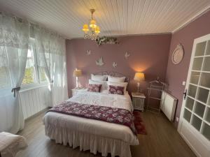 a bedroom with a bed and a chandelier at Gite Riquewihr "C'est Beau la Vie Alsace" in Riquewihr