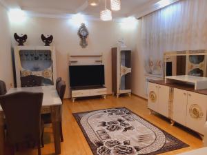 a living room with a table and a tv and a dining room at Cosmos villa in Gabala
