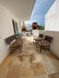 阿基拉斯的住宿－Casa em Condomínio, Aquiraz - CE，一个带椅子和一张桌子的墙壁庭院