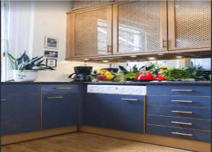 een keuken met blauwe kasten en groenten en fruit bij KNIGHTSBRIDGE early AM check-in often possible -Next2 HARRODS 3 BEDROOMS-2Baths in Londen