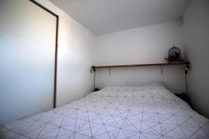 ein Schlafzimmer mit einem Bett mit einer weißen Tagesdecke in der Unterkunft Villa Mer Nature in Frontignan
