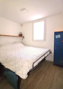 ein Schlafzimmer mit einem Bett in einem Zimmer mit einem Fenster in der Unterkunft Villa Mer Nature in Frontignan