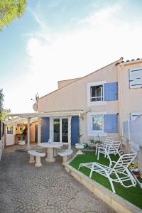 une terrasse avec une table et des chaises devant un bâtiment dans l'établissement Villa Mer Nature, à Frontignan