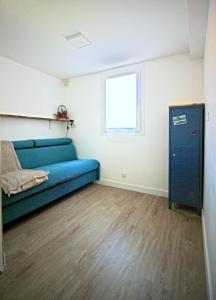 ein Wohnzimmer mit einem blauen Sofa und einem Fenster in der Unterkunft Villa Mer Nature in Frontignan