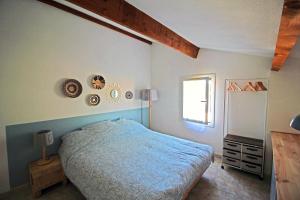 ein Schlafzimmer mit einem blauen Bett und einem Fenster in der Unterkunft Villa Mer Nature in Frontignan