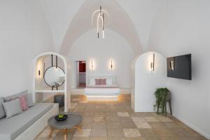 uma sala de estar com um sofá e uma mesa em Asha Luxury Suites em Fira