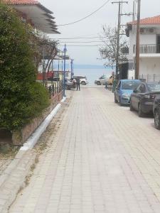a sidewalk with cars parked on the side of a street at Iliada's apartment in Polychrono