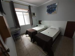 Habitación pequeña con 2 camas y ventana en OYO Hotel Village,São Paulo, en São Paulo