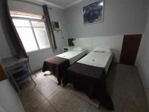 a room with two beds and a window at OYO Hotel Village,São Paulo in São Paulo