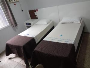 2 camas en una habitación pequeña con baño privado en OYO Hotel Village,São Paulo, en São Paulo