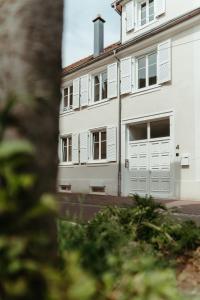 - un bâtiment blanc avec des portes et des fenêtres blanches dans l'établissement La DOLCE Villetta - appartement de Standing, à Mulhouse