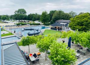 una piscina con un tobogán en un parque en Ferienhaus LuxChalet #VAJU Lathum# am See, Strand, Pool, Nationalpark en Lathum