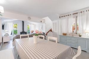 a dining room with a table with a vase of flowers on it at Gorgeous renovated Cala Sant Vicenc Beach Villa in Cala de Sant Vicenc