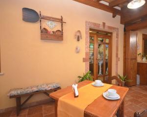 uma sala de jantar com uma mesa e um banco em Cascina degli Ulivi em Castelluzzo