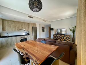 エル・カンページョにあるGran terraza Muchavista San Juan Alicanteのキッチン、リビングルーム(木製テーブル付)