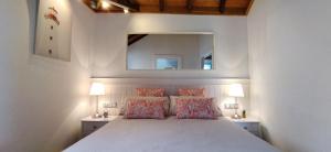 una camera da letto con un grande letto bianco e uno specchio di casa mo Tenerife a Garachico