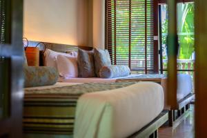 a bedroom with two beds with pillows at Centara Grand Beach Resort & Villas Krabi in Ao Nang Beach