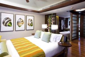 a bedroom with a large bed with four pictures on the wall at Centara Grand Beach Resort & Villas Krabi in Ao Nang Beach