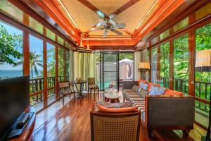 a living room filled with furniture and a large window at Centara Grand Beach Resort & Villas Krabi - SHA Plus in Ao Nang Beach