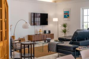 uma sala de estar com um sofá e uma televisão em LV Premier Algarve FU1- pool, AC, garden, sea view em Moncarapacho