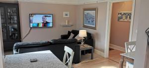 a living room with a couch and a tv on the wall at Flat 12 Sebastian Court - 2 beds with a four poster in Scarborough