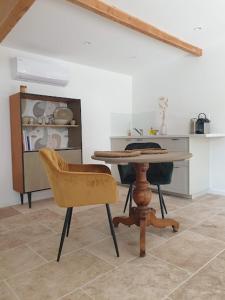 a dining room with a table and a chair at Mas des muses in LʼIsle-sur-la-Sorgue