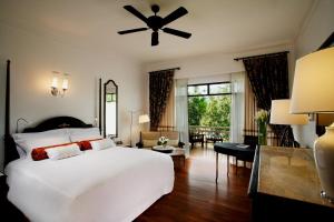 1 dormitorio con 1 cama blanca grande y ventilador de techo en Centara Grand Beach Resort & Villas Hua Hin, en Hua Hin