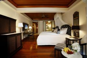 een slaapkamer met een groot wit bed en een tafel bij Centara Grand Beach Resort & Villas Hua Hin in Hua Hin