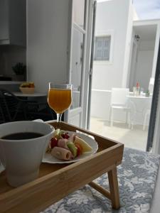 una mesa con un plato de comida y una copa de vino en Zoumis Residence en Náousa